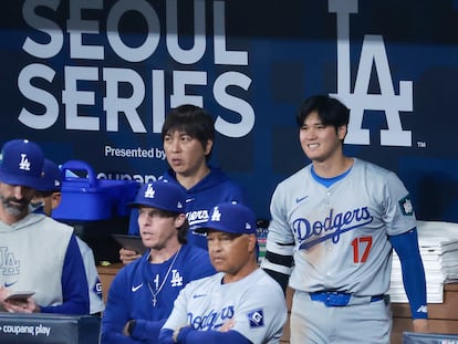Los Angeles Dodgers star player Shohei Ohtani (R) and his interpreter Ippei Mizuhara (C) look at the Dodgers' MLB season-opening game against the San Diego Padres in Seoul, South Korea, 20 March 2024.