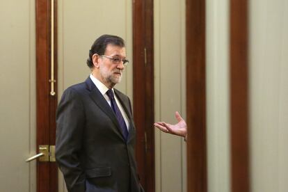 El presidente del Gobierno, Mariano Rajoy, hablando con alguien en un pasillo de Congreso de los Diputados, durante una sesión de control al Gobierno, el15 de febrero de 2017. 