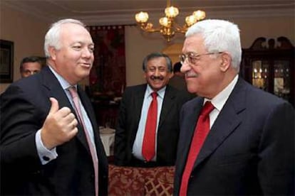 El presidente de la ANP, Mahmud Abas (dcha.), y el ministro de Exteriores Miguel Angel Moratinos (izqda.) conversan durante la reunión que mantuvieron en Jordania.