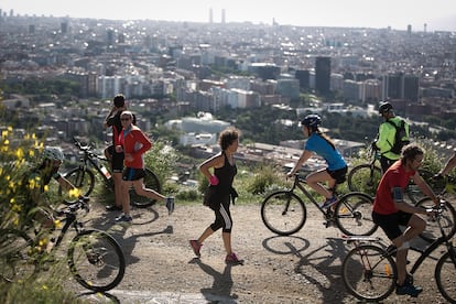 Ciclista y corredores salen a hacer deporte por la Carretera de les Aigües, en Barcelona.