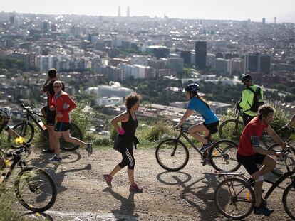 Ciclista y corredores salen a hacer deporte por la Carretera de les Aigües, en Barcelona.