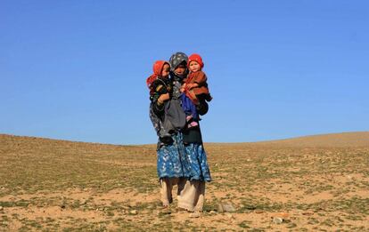 Una mujer afgana con dos niños espera a que la hagan entrega de mantas para el invierno durante un programa de distribución de ayuda en Herat. Décadas de conflicto han dejado Afganistán con una de las poblaciones de desplazados más altos del mundo. La agencia de refugiados de la ONU estima en 450.000, pero Amnistía Internacional ha dicho que el número real es probablemente mucho mayor.