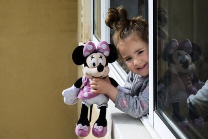 Catalina se asoma el 20 de marzo por la ventana para enseñarle a su vecina un muñeco de Minnie.