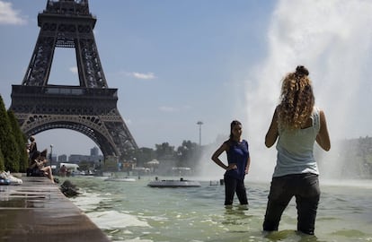 Varias personas se refrescan en la fuente de la plaza de Trocadero, cerca de la Torre Eiffel en París, Francia.