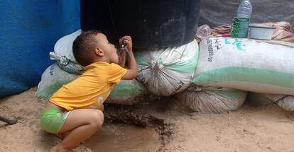 Un niño palestino bebe agua bombeada y almacenada gracias a un sistema ideado por Abdallah Aljazzar y su familia, desplazados en la zona de Al Mawasi, en el sur de la franja de Gaza, el 11 de septiembre de 2024.