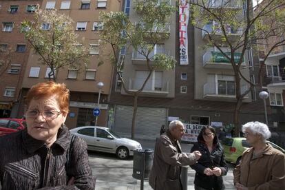 Ana, a la izquierda, propietaria de dos pisos en el edificio &#039;ocupado&#039; en Nou Barris, al fondo.