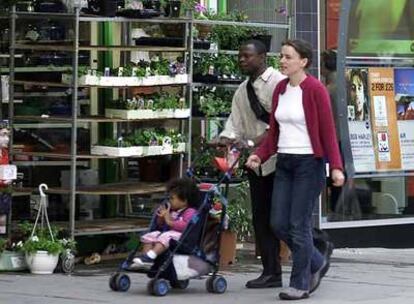 Una pareja  pasea con su hijo por una calle de Londres.