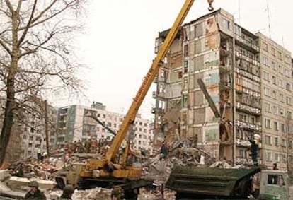 Empleados del servicio de emergencias trabajan en los restos del bloque destruido por una explosión.