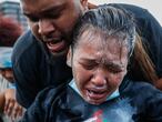 A protester reacts after being hit by pepper spray from police as their group of demonstrators are detained prior to arrest at a gas station on South Washington Street, Sunday, May 31, 2020, in Minneapolis. Protests continued sparked by the death of George Floyd, who died after being restrained by Minneapolis police officers on May 25.  (AP Photo/John Minchillo)