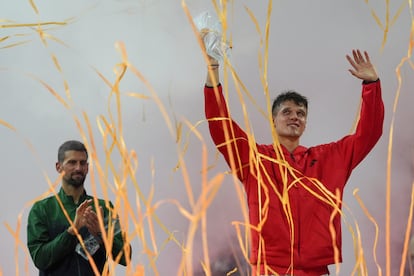 Mensik posa con el trofeo de campeón, con Djokovic en segundo término.