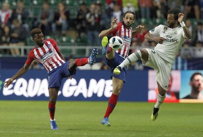 Thomas Lemar del Atlético, Juanfran y Marcelo del Real Madrid compiten por el balón.