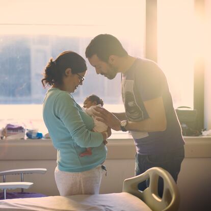 Parents taking care of newborn ant the hospital room.