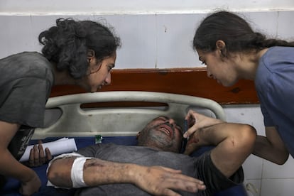 Dos niñas conversan con un familiar herido tras los ataques israelíes, en un hospital de Rafah, al sur de la franja de Gaza, este lunes.