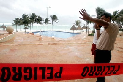 El personal de un hotel asegura la zona más expuesta del establecimiento al Caribe en Cancún, mientras las olas rugen y sólo unas horas antes de que el ojo del huracán alcance la zona.
