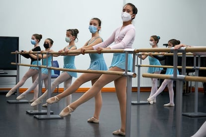 Alumnas de segundo de elemental ejecutan ejercicios en la barra en su clase de danza clásica.