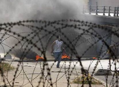 Un partidario del grupo chií Hezbolá corre hacia una barricada situada en un edificio del Gobierno ayer en Beirut.