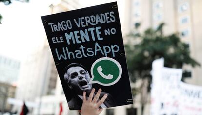 A woman holds a sign with the image of presidential candidate Jair Bolsonaro that reads 