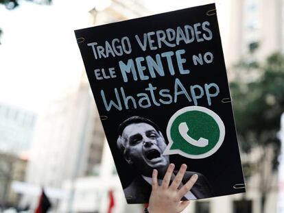 A woman holds a sign with the image of presidential candidate Jair Bolsonaro that reads 