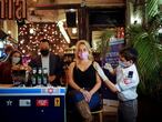 FILE PHOTO: A woman receives a vaccination shot against the coronavirus disease (COVID-19) as part of a Tel Aviv municipality initiative offering a free drink at a bar to residents getting the shot, in Tel Aviv, Israel February 18, 2021. REUTERS/Corinna Kern/ File Photo