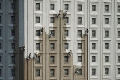 Trabajadores pintan la fachada de un edificio en Shenyang, China.