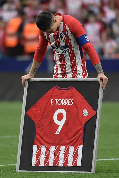 Fernando Torres emocionado al recibir una camiseta firmada por sus compañeros.