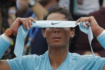 Rafael Nadal ajusta a fita para o cabelo.