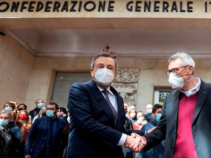 El primer ministro de Italia, Mario Draghi (izquierda), saluda este lunes al secretario general de CGIL, Maurizio Landini, frente a la sede en Roma del sindicato atacado este fin de semana por grupos fascistas.