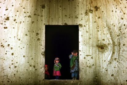 Un grupo de niños se asoma a una de las ventanas de la antigua embajada soviética en Kabul, el 27 de noviembre de 2001.