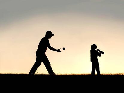 Un padre juega con su hijo al beisbol.
