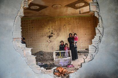 Una mujer y sus hijos posan en su casa en ruinas en la ciudad kurda de Silopi, Turquía.