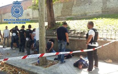 Police stand guard over several of the gang of 10 thieves, who were arrested after robbing a bank via the sewer system.