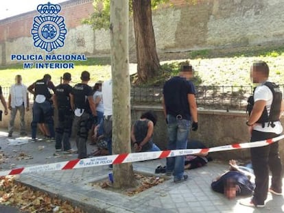 Police stand guard over several of the gang of 10 thieves, who were arrested after robbing a bank via the sewer system.