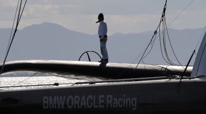 Un miembro de la tripulación del BMW Oracle espera que lleguen buenas condiciones climatológicas en el puerto de Valencia para empezar a navegar.