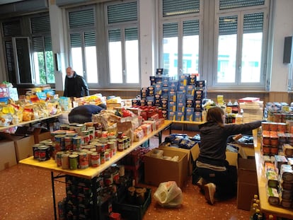 Varios voluntarios reparten comida en una iglesia en Roma, este lunes.