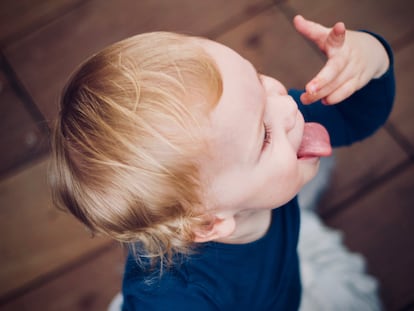 Un niño juega con su mano.