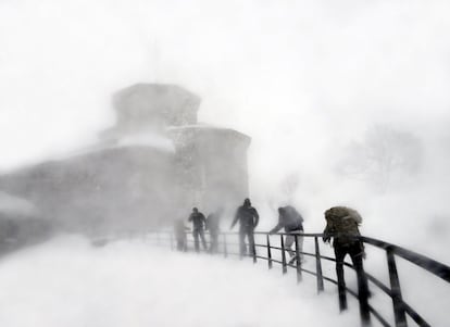 Varios jóvenes acceden, en medio de una fuerte ventisca, al Santuario de San Miguel de Aralar (Navarra).