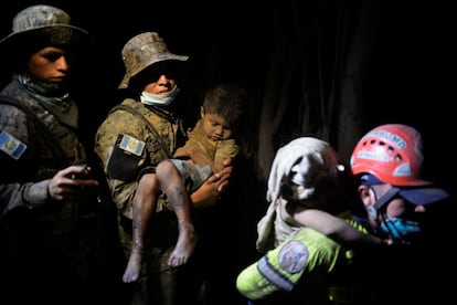 Un soldat trasllada un nen cobert de cendra a un hospital d'El Rodeo, el 3 de juny.