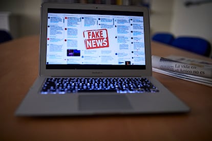 Una persona lee en su ordenador portátil una noticia falsa.
