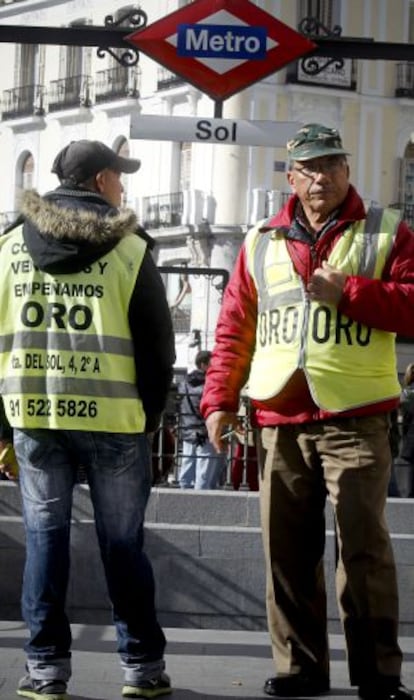 Two gold buyers try to attract the attention of passers-by in downtown Madrid.