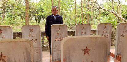 Duong Van Dau posa junto a las lápidas de los 14 pilotos norcoreanos