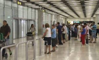 Varias personas aguardan la aparición de amigos y familiares en la sala de llegadas de la T4 del aeropuerto de Madrid-Barajas. EFE/Archivo