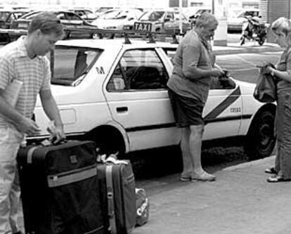 Varios pasajeros, antes de montar en un taxi en la estación de Atocha.