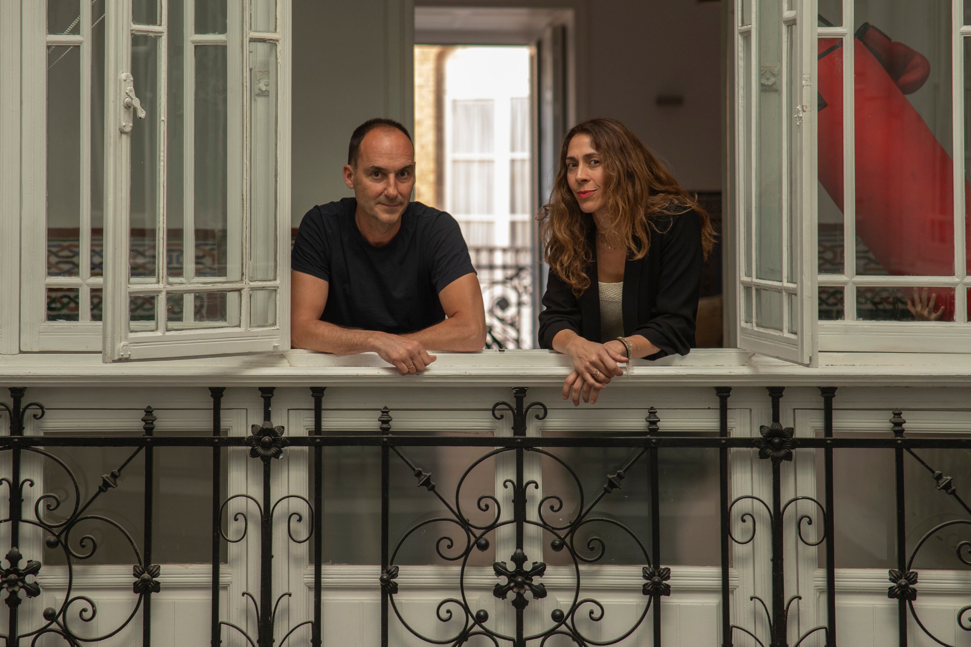 Guillermo Marín y Rocío Castillo, asomados al patio interior de su piso en la calle Hermanos Álvarez Quintero.