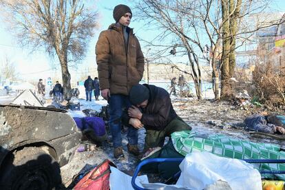 Dos hombres se lamentan junto al cuerpo de un familiar muerto, a causa de un ataque con misiles a la ciudad de Donetsk, este domingo.