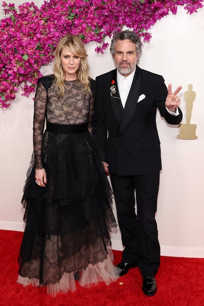 Sunrise Coigney, con un vestido de encaje, y su marido, Mark Ruffalo, nominado como mejor actor de reparto por 'Pobres criaturas'. Él, además de un broche, lleva en la solapa la chapa que pide el alto el fuego en Gaza.