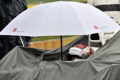 El piloto japonés se protege de la lluvia.