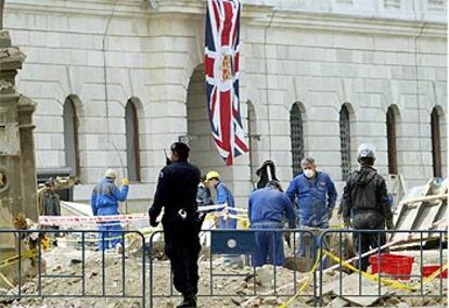 Un policía turco vigila los trabajos de desescombro del Consulado británico tras el atentado del pasado día 20.