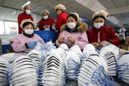 Esta foto tomada el 22 de enero de 2020 muestra a los trabajadores que producen máscaras faciales en una fábrica en Handan, en la provincia de Hebei, en el norte de China.