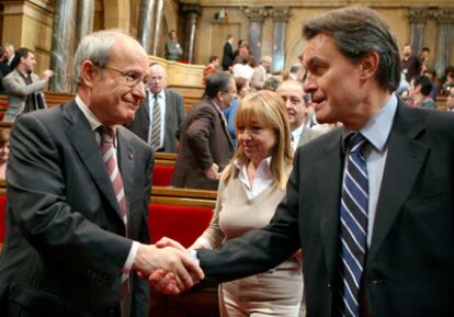 El presidente de la Generalitat, José Montilla, y el lider de Convergencia i Unió ( CiU ), Artur Mas , se estrechan la mano tras aprobar el Parlamento catalán la resolución en la que piden la renovación del Constitucional y que se declare incompetente para dictaminar sobre el Estatut.