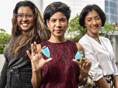 Las tres hermanas posan con la copa menstrual.